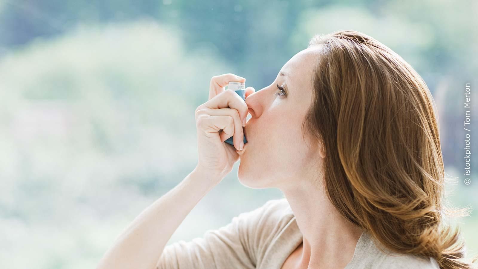 Frau mit einem Asthmaspray