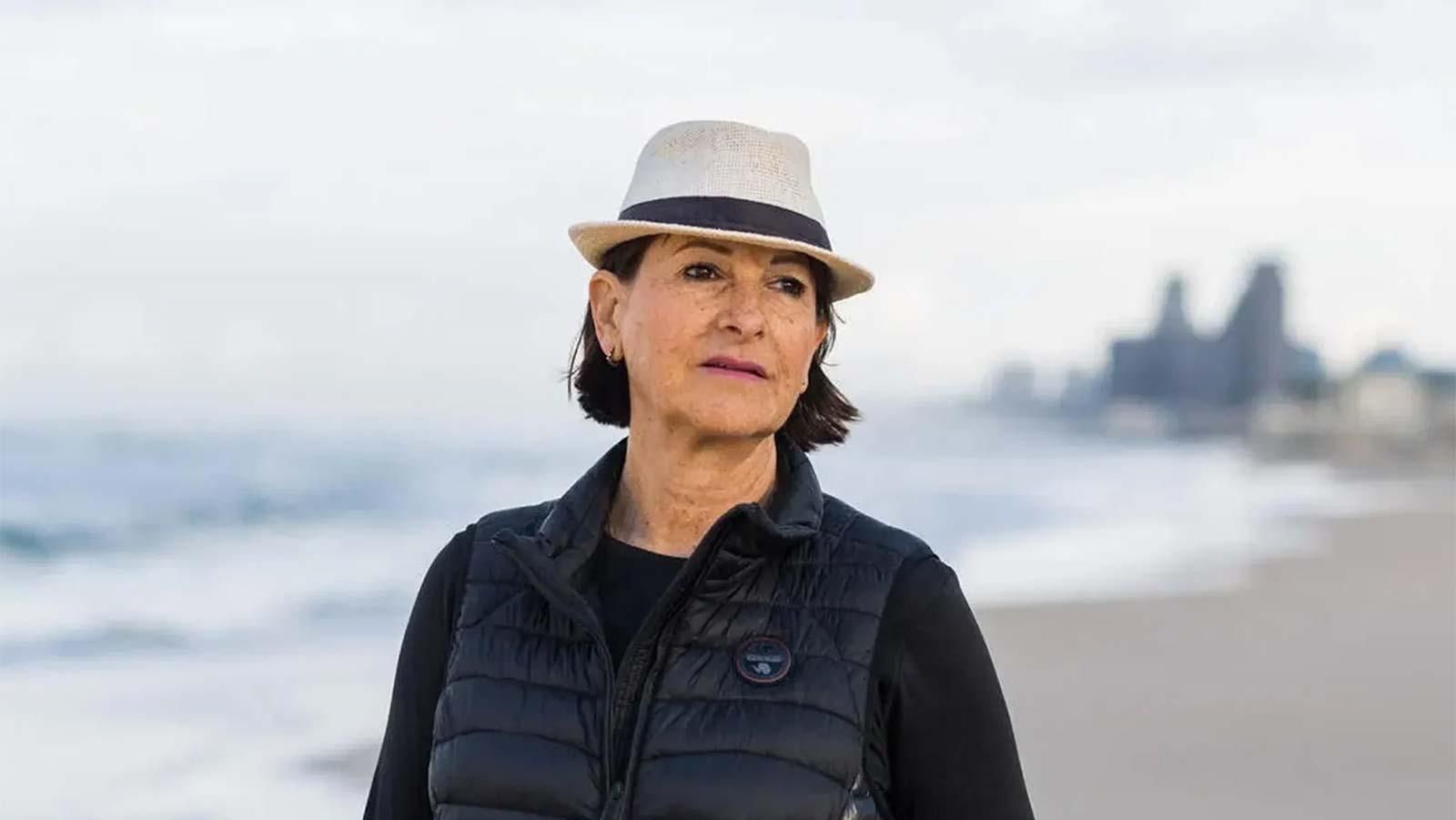 Frau mit Hut an einem Strand