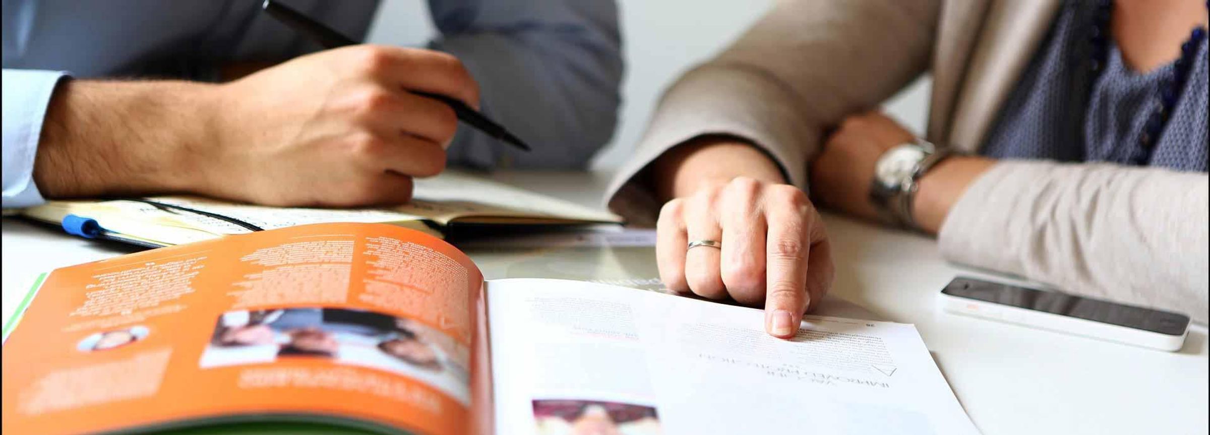 Eine Frau und ein Mann schauen sich gemeinsam einen Report an